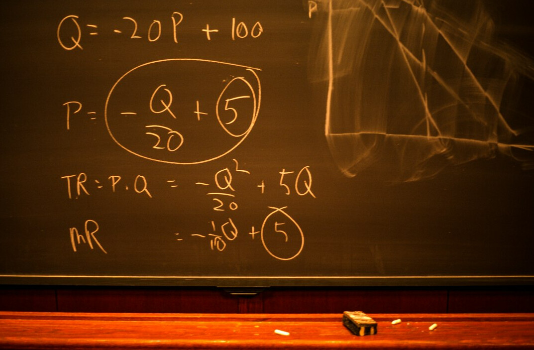Whiteboard filled with a flowchart and algorithm diagram with a marker in the foreground